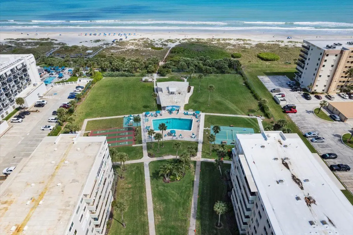 Aerial view of oceanfront condominiums and a pool along a Space Coast beach
